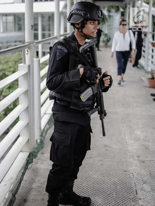 Seorang anggota Brimob bersenjata lengkap berjaga di JPO kawasan Bunderan HI, Jakarta, Jumat (11/5). Penjagaan tersebut dilakukan untuk antisipasi kegiatan Aksi 115 Pembebasan Baitul Maqdis yang berpusat di Monas. (Liputan6.com/Faizal Fanani)