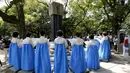 Sejumlah Wanita bernyanyi di depan Momumen Perdamaian yang didedikaasikan untuk memperingati 70 tahun  serangan bom terhadap Hiroshima, Jepang, Rabu  (5/8/2015). Bom atom di Hiroshima menewaskan hampir 140.000. (REUTERS/Toru Hanai)