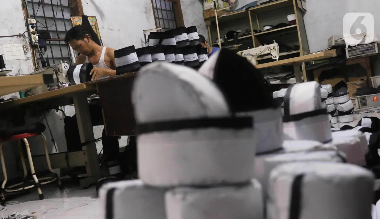 Pengrajin songkok (peci) sedang mengerjakan pesanan berbagai jenis peci di  Pasar Kemis, Kabupaten Tangerang, Banten, Minggu (18/4/2021). Pesanan songkok bermerk Bulan Bintang Mas Haji Sanusi mengalami peningkatan  pada bulan puasa. (Liputan6.com/Angga Yuniar)