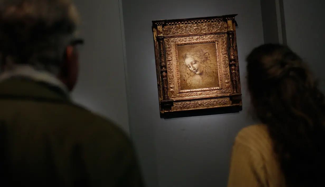 Awak media melihat lukisan "The Disheveled" karya Leonardo Da Vinci di museum Louvre, Paris, Selasa (22/10/2019). Louvre Paris, rumah Mona Lisa, menggelar pameran terbesar  Leonardo da Vinci memperingati 500 tahun wafatnya maestro Italia itu yang dibuka pada 24 Oktober mendatang. (AP/Thibault Camus)