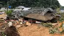 Pemandangan menunjukkan rumah yang roboh setelah tanah longsor yang disebabkan hujan lebat di Ashikita, Prefektur Kumamoto, Jepang, Minggu (5/7/2020). Banjir di wilayah Kumamoto ini telah menghancurkan ratusan rumah dan kendaraan serta membuat jembatan antar kota terputus. (STR/JIJI PRESS/AFP)