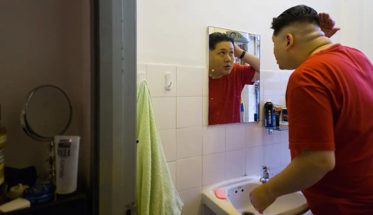 Howard X yang mirip Kim Jong-un merapihkan rambutnya di studionya di Hong Kong (7/6). Howard X telah menjadi terkenal karena kemiripannya dengan pemimpin Korut Kim Jong-un sedang mempersiapkan untuk penampilannya di Singapura. (AFP Photo/Anthony Wallace)