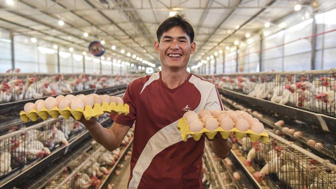 Qin Yongling menunjukkan telur ayam dari peternakannya di Desa Renyuan, Kota Jinji, Wilayah Wuxuan, Daerah Otonom Etnis Zhuang Guangxi, China, 18 Juni 2020. Guangxi melakukan percepatan pembangunan infrastruktur transportasi di daerah miskin dan pelaksanaan proyek air minum. (Xinhua/Cao Yiming)