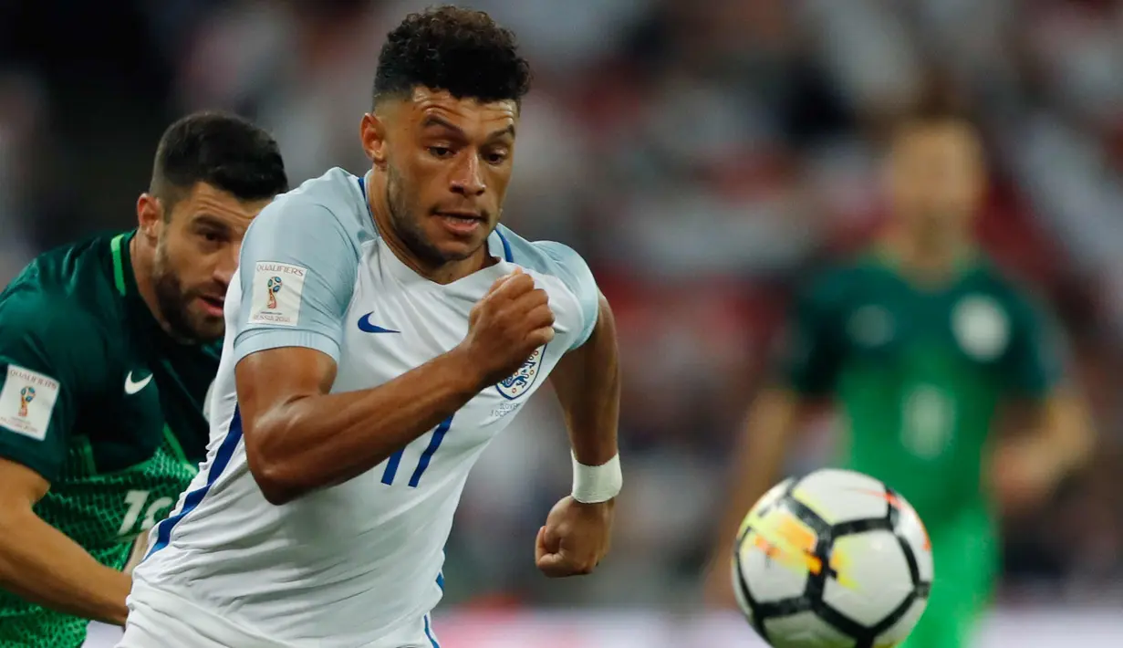 Gelandang Inggris, Alex Oxlade-Chamberlain membawa bola dari kejaran pemain Slovenia Rene Krhin pada grup F kualifikasi Piala Dunia 2018 di stadion Wembley, London, (5/10). Inggris lolos ke Piala Dunia 2018 berkat menang 1-0. (AP Photo/Frank Augstein)