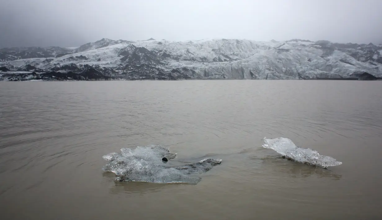 Foto yang diambil 16 Oktober 2015 menunjukkan bongkahan es terapung di perairan Gletser Solheimajokull, Islandia. Pemanasan global menyebabkan gletser Solheimajokull mencair hingga 1 km sejak pengukuran tahunan pada 1931. (AFP PHOTO/POOL/Thibault Camus)