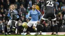 Penyerang Manchester City, Bernardo Silva, berusaha melewati pemain Leicester City pada laga Premier League 2019 di Stadion Etihad, Sabtu (21/12). Manchseter City menang 3-1 atas Leicester City. (AP/Rui Vieira)