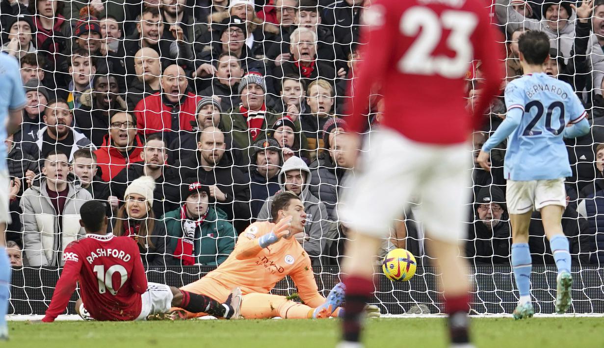 Pemain MU, Marcus Rashford (kiri) berhasil menjebol gawang Manchester City yang dijaga oleh Ederson dalam pertandingan lanjutan Liga Inggris 2022/2023. Gol ini membuat kedudukan menjadi 2-1 bagi kemenangan MU. (AP Photo/Dave Thompson)