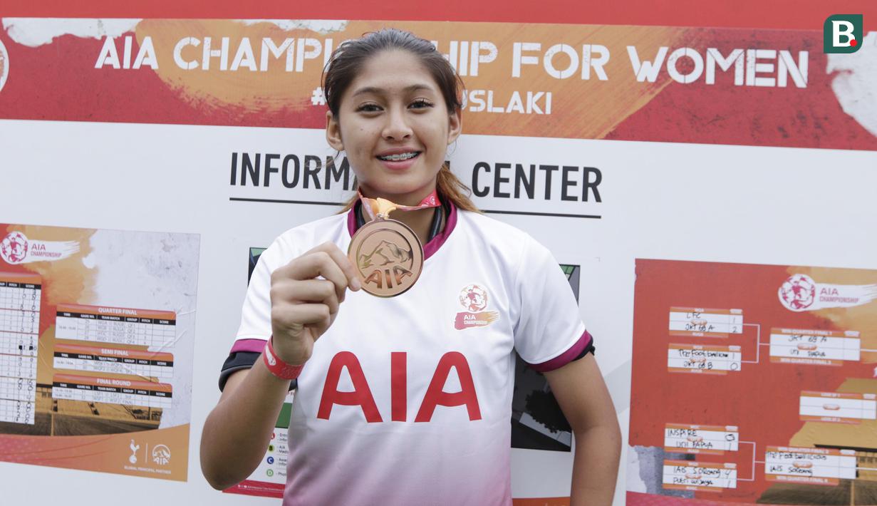 Pemain Jakarta 69, Zahra Muzdalifah, menunjukan medali saat Kompetisi Nasional AIA Championship di Lapangan TNI AU, Pancoran, Jakarta, Sabtu (01/12). Dari turnamen ini akan dipilih 16 orang untuk bertanding di Bangkok, Thailand. (Bola.com/M Iqbal Ichsan)