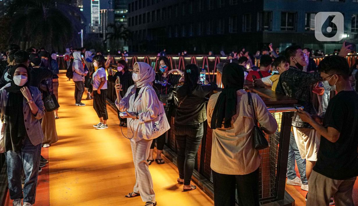 Warga berada di balkon Jembatan Penyeberangan Orang dan Sepeda (JPOS Phinisi) di Karet, Jakarta, Minggu (20/3/2022). JPOS Phinisi kini menjadi objek baru bagi warga Jakarta. (Liputan6.com/Faizal Fanani)