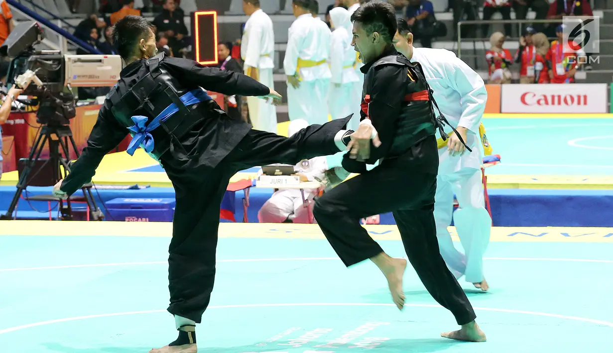 Pesilat Indonesia, Iqbal Candra Pratama saat bertarung melawan Pesilat Thailand, Porntep Poolkaew di Arena Pendopo Pencak Silat TMII, Jakarta, Kamis (23/8). Pesilat Iqbal unggul dengan skor 5-0 dan berhasil masuk ke 8 besar. (Liputan6.com/Fery Pradolo)