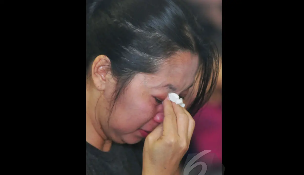 Seorang Ibu mengusap air matanya saat menunggu kabar terbaru hilangnya pesawat AirAsia QZ8501 di posko Crisis Centre di Terminal II Bandara Juanda, Surabaya, Jawa Timur, Senin (29/12). (Liputan6.com/Johan Tallo)