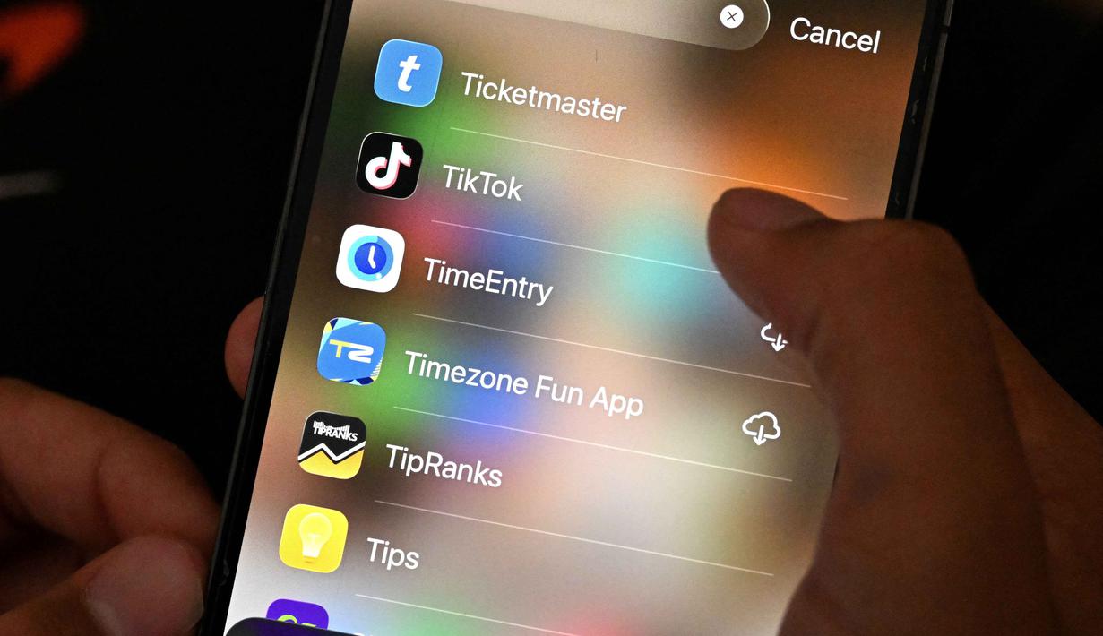 Dengan berlakunya aturan ini, platform media sosial seperti TikTok, Instagram, dan YouTube bakal memblokir lebih dari satu juta akun. Tampak dalam foto, seorang anak laki-laki berusia 13 tahun berpose di rumahnya sambil melihat media sosial di ponselnya di Sydney, Australia pada Senin 8 Desember 2025. (Saeed KHAN/AFP)