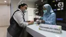 Seorang perempuan mengambil obat yang sudah diracik oleh tenaga  farmasi di RSIA Tambak, Jakarta, Jumat (21/10/2022). Puyer dapat menjadi substitusi sediaan sirup untuk anak -selama obat bebas dan/atau bebas terbatas cair dilarang Kementerian Kesehatan. (Liputan6.com/Herman Zakharia)
