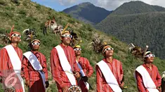 Seniman memakai kacamata melihat gerhana matahari di Bukit Matantimali, Sigi, Sulawesi Tengah, Rabu (9/3). Tarian tersebut dilakukan dalam rangka menyambut gerhana matahari total serta menolak bala. (Liputan6.com/Immanuel Antonius)