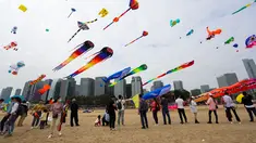 Orang-orang menerbangkan layang-layang dalam festival layang-layang di Xiamen, Provinsi Fujian, China tenggara (21/11/2020). Ratusan layang-layang diterbangkan peserta menghiasi langit wilayah China tenggara. (Xinhua/He Huan)