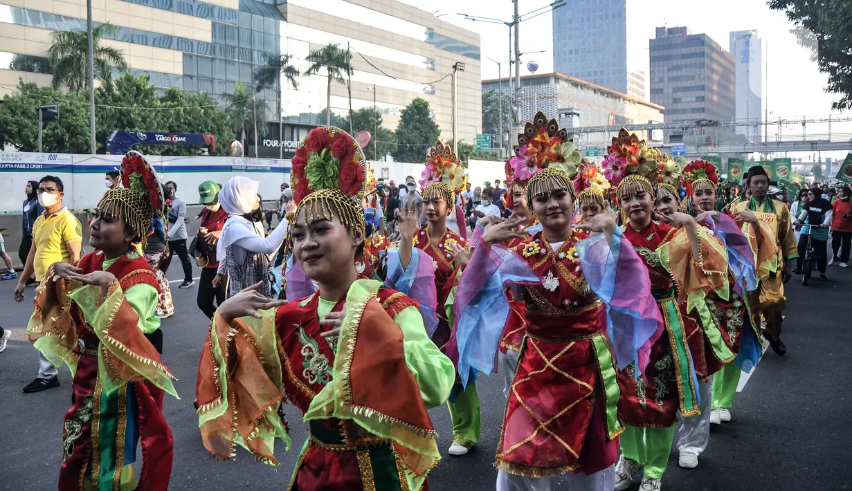 Para penari tampil dalam pawai budaya dan kesenian Betawi saat Hari Bebas Kendaraan Bermotor (HBKB) atau car free day (CFD) di Jalan MH Thamrin, Jakarta, Minggu (19/6/2022). Pawai yang menampilkan berbagai budaya dan kesenian Betawi seperti ondel-ondel, tari topeng, serta tanjidor tersebut digelar dalam rangka menyambut HUT ke-495 DKI Jakarta. (merdeka.com/Iqbal S. Nugroho)