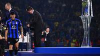 Lautaro Martinez berjalan lesu di samping trofi Liga Champions. Inter Milan hanya runner up usai kalah 0-1 dari Manchester City (AFP)