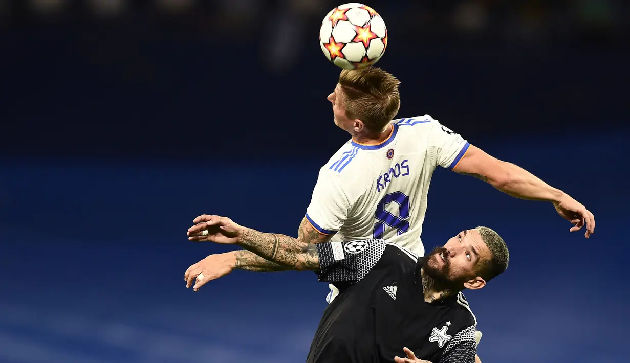 Gelandang Real Madrid, Toni Kroos berebut bola udara dengan pemain Sheriff, Dimitris Kolovos pada pertandingan grup D Liga Champions di stadion Bernabeu di Madrid, Spanyol, Rabu (29/9/2021) WIB. (AP Photo/Jose Breton)