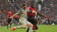 Paul Pogba mencoba menghentikan James Milner pada laga lanjutan Premier League yang berlangsung di stadion Old Trafford, Manchester, Minggu (24/2). Man United bermain imbang 0-0 kontra Liverpool. (AFP/Oli Scarff)