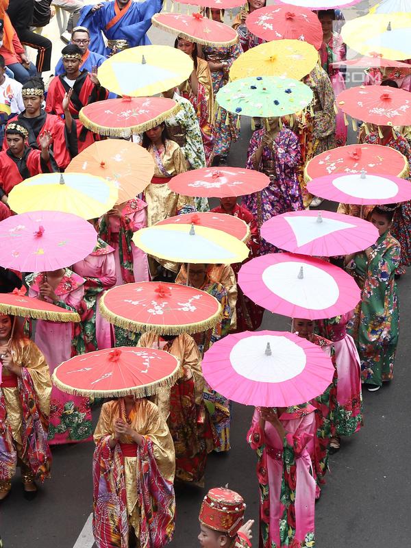 Peserta memakai kostum tradisional saat meramaikan pawai obor Asian Para Games 2018 di Jakarta, Minggu (30/9). Pawai obor dimulai dari Balai Kota DKI Jakarta dan berakhir di Gedung Kementerian Pemuda dan Olahraga. (Liputan6.com/Herman Zakahria)