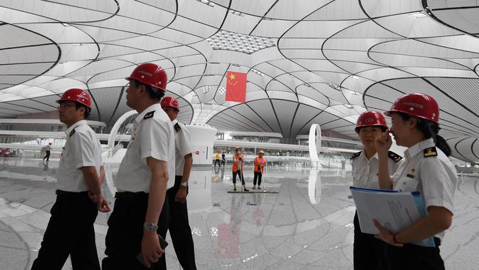 Pejabat pabean berkeliling Terminal Bandara Internasional Daxing Beijing, China, Selasa (9/7/2019). Bandara Internasional Daxing Beijing menerapkan desain ruang terbuka. (GREG BAKER/AFP)
