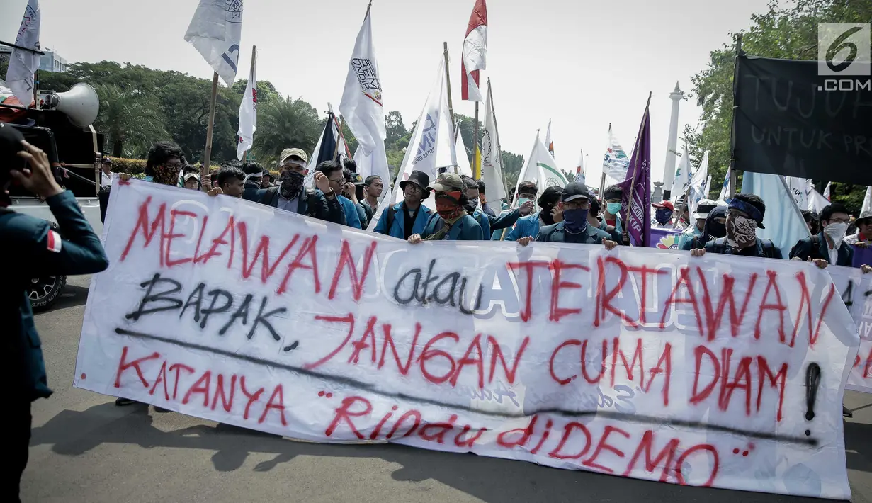 Sejumlah peserta aksi yang tergabung dalam Aliansi Badan Eksektutif Mahasiswa Seluruh Indonesia (BEM SI) membawa spanduk saat mengikuti aksi longmarch menuju Istana Merdeka, Jakarta, Senin (22/5). (Liputan6.com/Faizal Fanani)