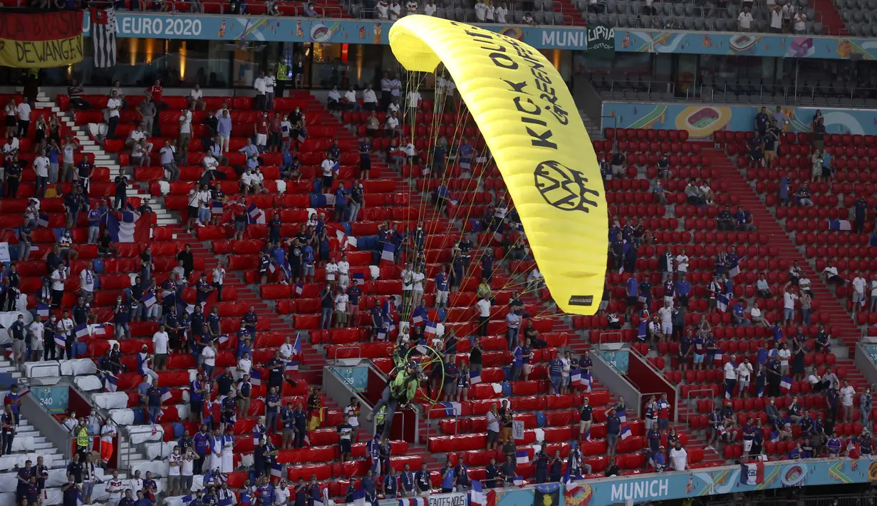 Aktivis tersebut hampir kehilangan kendali saat paraglidernya mau mendarat di tengah lapangan dan hampir menabrak para penonton di stadion. (Foto: AP/Pool/Alexander Hassenstein)