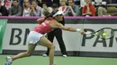 Martina Hingis berusaha mengembalikan bola pukulan Urszula Radwanska. (AFP PHOTO/PIOTR HAWALEJ)