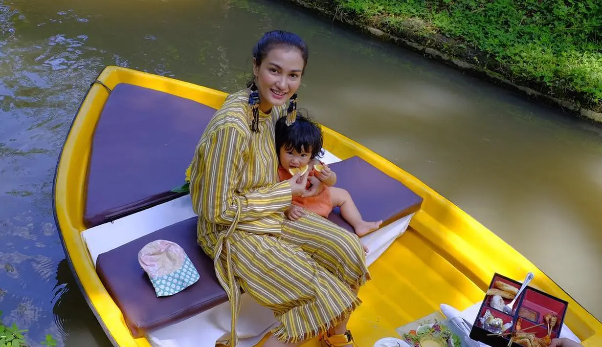 Sejak lahir, Sal memang selalu berada di sisi sang ibu. Kemanapun Atiqah pergi, Sal selalu bersamanya. Seperti yang satu ini misalna, keduanya tampak asik berada di atas perahu kayu.  (Instagram/atiqahasiholan)