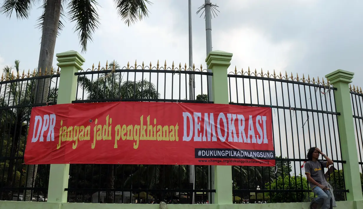 Spanduk kecaman terhadap keputusan disahkannya UU Pilkada terpampang di pagar halaman gedung DPR RI, Jakarta, (14/10/2014). (Liputan6.com/Helmi Fithriansyah)
