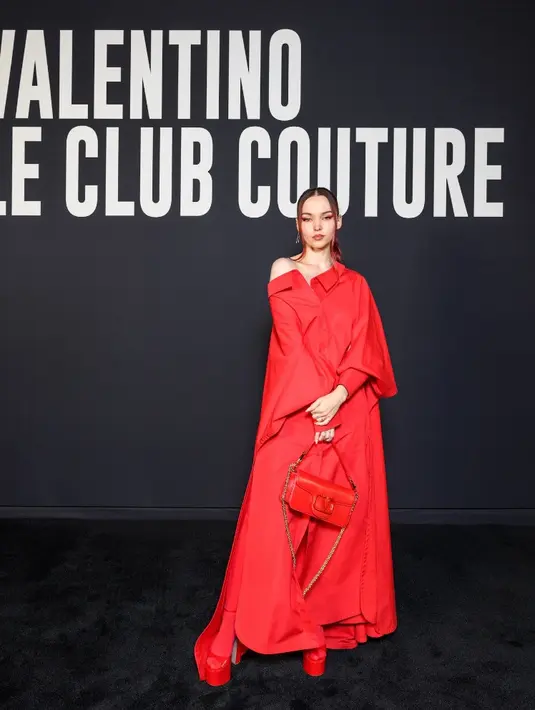 Dove Cameron tampil serba merah, mulai dari dress koleksi  Spring Summer 2023 Unboxing. Serta sepatu dan tas merah koleksi Valentino Garavani Loco. Credit: Valentino/SGP Italia