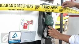 Garis polisi terpasang di mesin pompa solar yang diduga bercampur air di SPBU Jalan Juanda, Depok, Senin (14/11). Polresta Kota Depok menyegel dan menutup sementara SPBU tersebut lantaran diduga mencampur solar dengan air. (Liputan6.com/Yoppy Renato)
