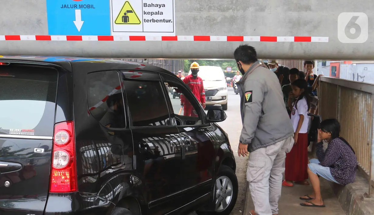 Warga mengatur lalu lintas kendaraan yang melintas di Jembatan Antelope, Curug, Bekasi, Jawa Barat, Selasa (14/6/2022). Jembatan Antelope masih ramai dilintasi warga meski pemasangan box girder jalur Kereta Cepat Jakarta-Bandung hampir menghalangi jalanan. (Liputan6.com/Herman Zakharia)