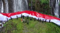 Pengibaran bendera merah putih raksasa di wisata Air terjun Coban Sewu Panorama Tumpak Sewu, Kecamatan Pronojiwo Lumajang. (Dian Kurniawan/Liputan6.com)