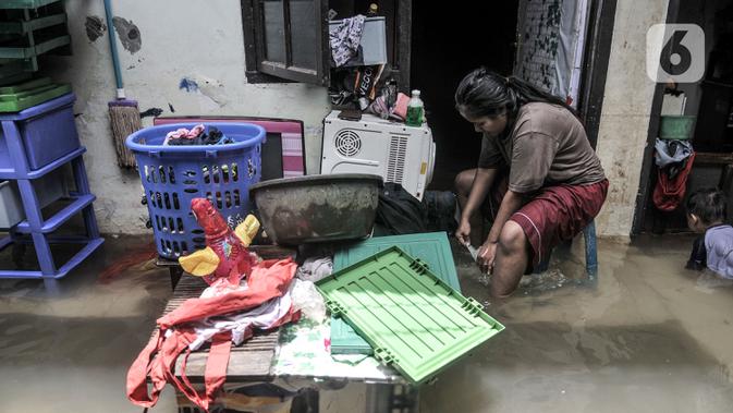 Warga mencuci pakaian saat banjir merendam permukiman warga di kawasan Kemang Timur XI, Jakarta Selatan, Minggu (21/2/2021). Warga berharap pemerintah segera memperbaiki longsor agar banjir tidak berkepanjangan. (merdeka.com/Iqbal S. Nugroho)
