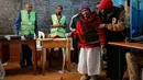 Lydia Gathoni Kiingati (102) menggunakan tongkat mendatangi sebuah TPS untuk memberikan suaranya di Gatundu, utara Nairobi, Selasa (8/8). Masyarakat Kenya melaksanakan pesta demokrasi dengan memberikan suara pada pemilihan presiden. (AP Photo/Ben Curtis)