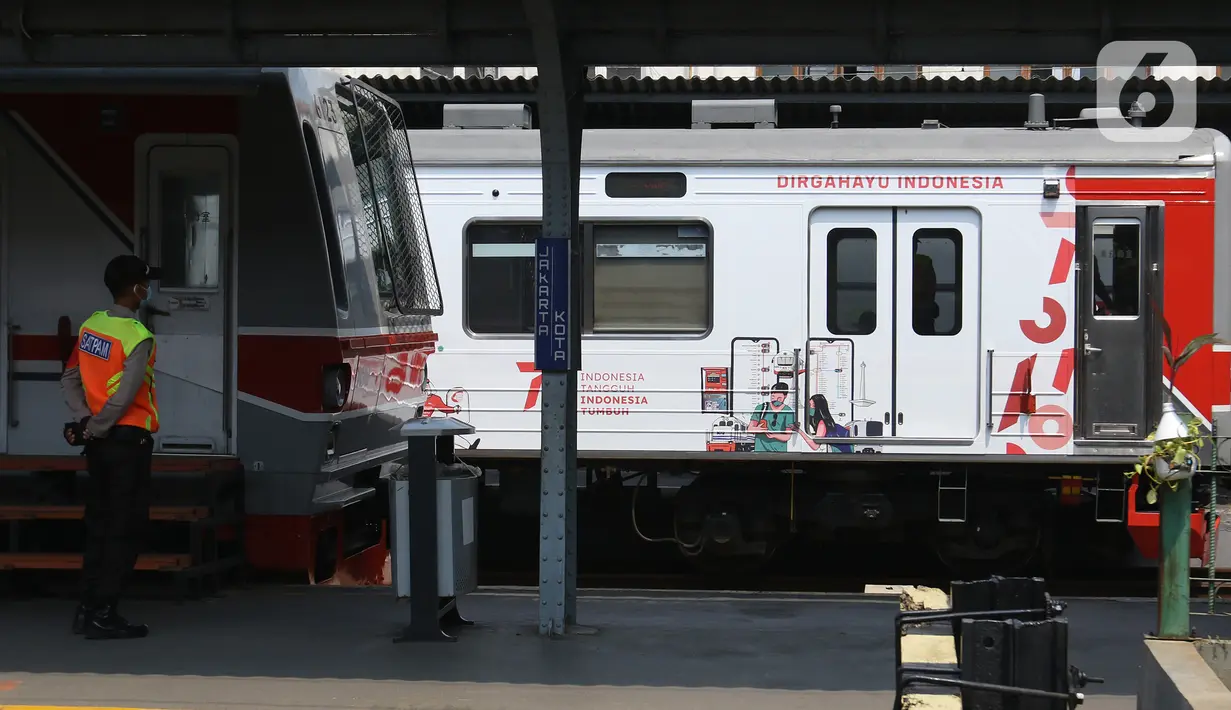 Petugas berjaga di dekat Gerbong KAI Commuter bertemakan Kemerdekaan Republik Indonesia ke-76 terpasang di gerbong yang membawa penumpang di Stasiun Kota, Jakarta, Selasa (17/8/2021). (Liputan6.com/Herman Zakharia)