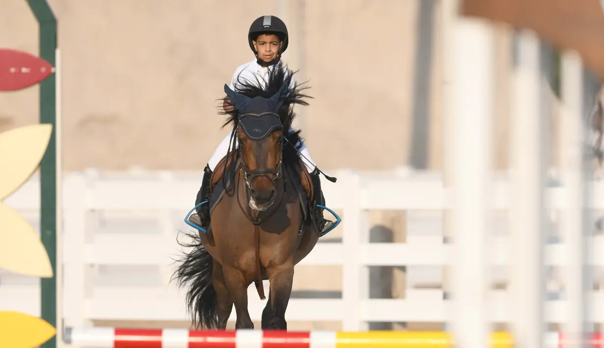 Seorang anak ambil bagian dalam latihan untuk mengawali Kejuaraan Lompat Kuda di Kuwait Riding Center di Kegubernuran Mubarak Al-Kabeer, Kuwait, pada 6 November 2020. Kuwait pada Jumat (6/11) meluncurkan Kejuaraan Lompat Kuda di Kuwait Riding Center di kegubernuran tersebut. (Xinhua/Ghazy Qaffaf)