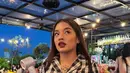 Cantika Abigail tampil mengenakan setelan tartan hitam, dari atasan kemeja crop dipadukan mini skirt pleated. Ia tampil sebagai karakter Dionne Davenport. [@abigailcantika]