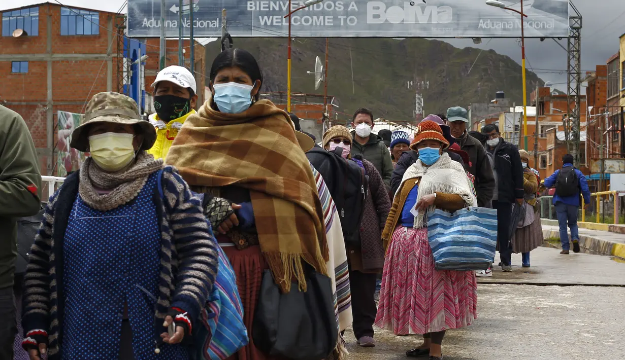 Warga Bolivia mengantre masuk ke perbatasan Peru untuk memasuki negara tersebut, di desa Desaguadero, Bolivia, pada 18 Februari 2022. Setelah ditutup selama hampir dua tahun karena pandemi Covid-19, Peru mengizinkan pembukaan kembali perbatasan dengan Bolivia dan Ekuador. (Carlos MAMANI/AFP)