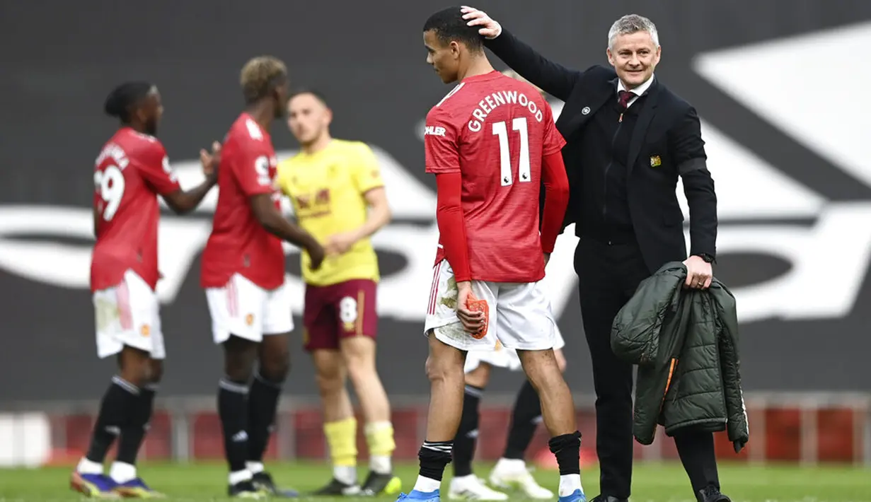 Manajer Manchester United Ole Gunnar Solskjaer menyapa pemainnya Mason Greenwood pada akhir pertandingan melawan Burnley pada pertandingan Liga Inggris di Stadion Old Trafford, Manchester, Inggris, Minggu (18/4/2021). Manchester United menang 3-1. (Gareth Copley/Pool via AP)