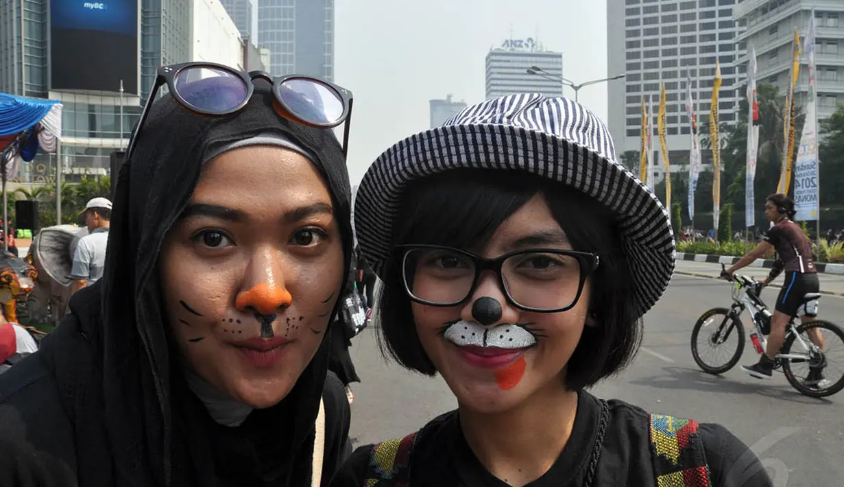 Para peserta tampak melukiskan wajahnya saat mengikuti aksi Karnaval untuk Bumi, Jakarta, (12/10/14). (Liputan6.com/Miftahul Hayat)