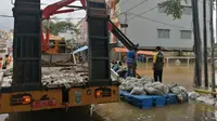 Dinas PUPR Kota Tangerang membuat tanggul sementara dengan barier beton dan karung berisi pasir. (Pramita/Liputan6.com).