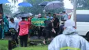 Jenazah aktor senior Deddy Sutomo saat diturunkan dari mobil ambulan. Siang itu, disekitar Tempat Pemakaman Umum Tanah Kusir, Jakarta Selatan sedang di guyur hujan. (Adrian Putra/Bintang.com)