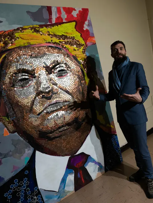 Seniman Inggris Daniel Green memberi keterangan lukisan Presiden AS Donald Trump yang dibuat oleh dirinya dan Daria Marchenko dengan menggunakan rangkaian koin di Akademi St George di New York (30/1). (AFP Photo/Don Emmert)