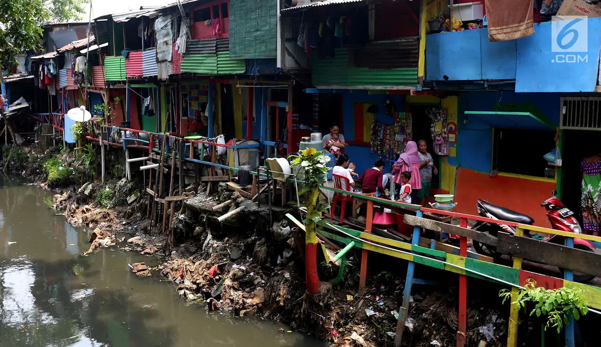 Warga beraktivitas dengan suasana dinding warna-warni di Kampung Penas Tanggul, Cipinang Besar Selatan, Jakarta, Kamis (2/11). Kampung warna-warni tanpa rokok itu dibuat sebagai bentuk upaya perlindungan bagi perempuan dan anak. (Liputan6.com/Johan Tallo)