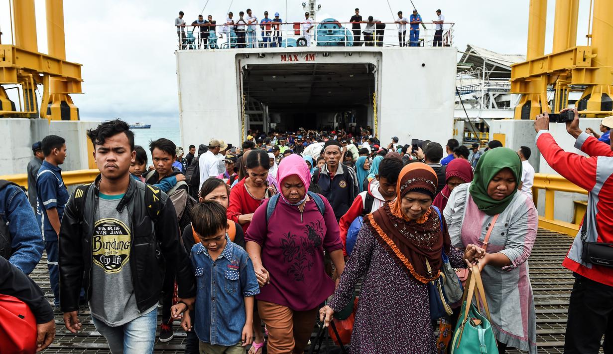 Para pengungsi turun dari kapal ferry usai dievakuasi dari Pulau Sebesi, di Pelabuhan Bakauheni, Lampung, Rabu (26/12). Ribuan pengungsi tsunami dari Pula Sebesi terpaksa dievakuasi menggunakan kapal ferry. (AFP Photo/Mohd Rasfan)