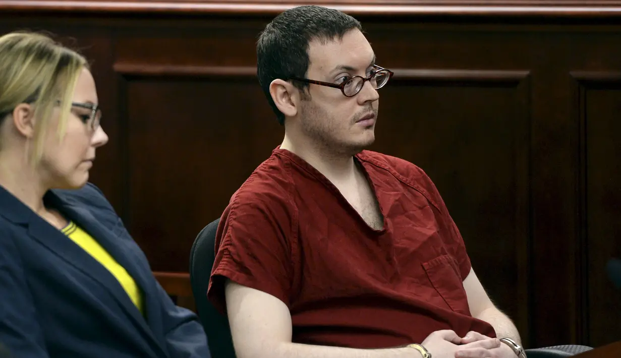 Terdakwa penembak di bioskop Colorado, James Holmes didampingi pengacaranya mengikuti sidang di Centennial, Colorado, Rabu (26/8). James dijatuhi hukuman penjara seumur hidup tanpa pembebasan bersyarat atas pembunuhan 12 orang.(REUTERS/RJ Sangosti/Pool)