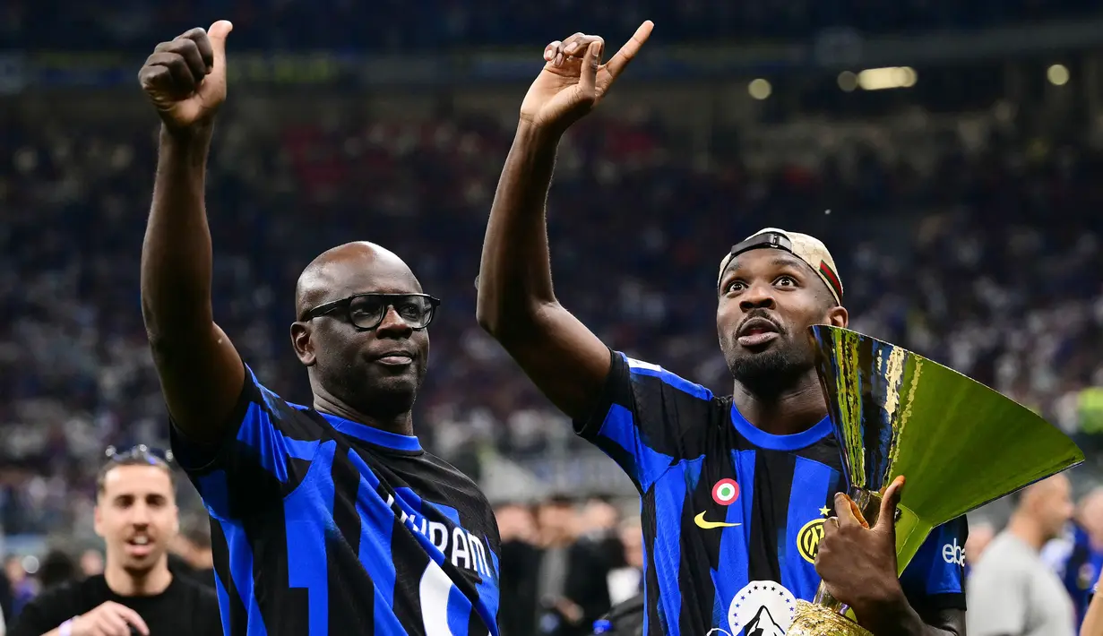 Pemain Inter Milan, Marcus Thuram, merayakan gelar juara Serie A bersama sang ayah yang juga seorang legenda Juventus yakni Lilian Thuram di Stadion Giuseppe Meazza, (19/5/2024). (AFP/Marco Bertorello)