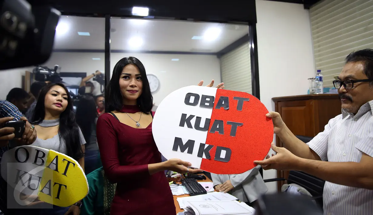 Dua wanita dari Indonesia Parlemen Watch (IP Watch) memberikan simbolik obat kuat saat menyambangi Mahkamah Kehormatan Dewan (MKD) DPR RI, di Kompleks Parlemen, Jakarta, Kamis (24/11). (Liputan6.com/Johan Tallo)